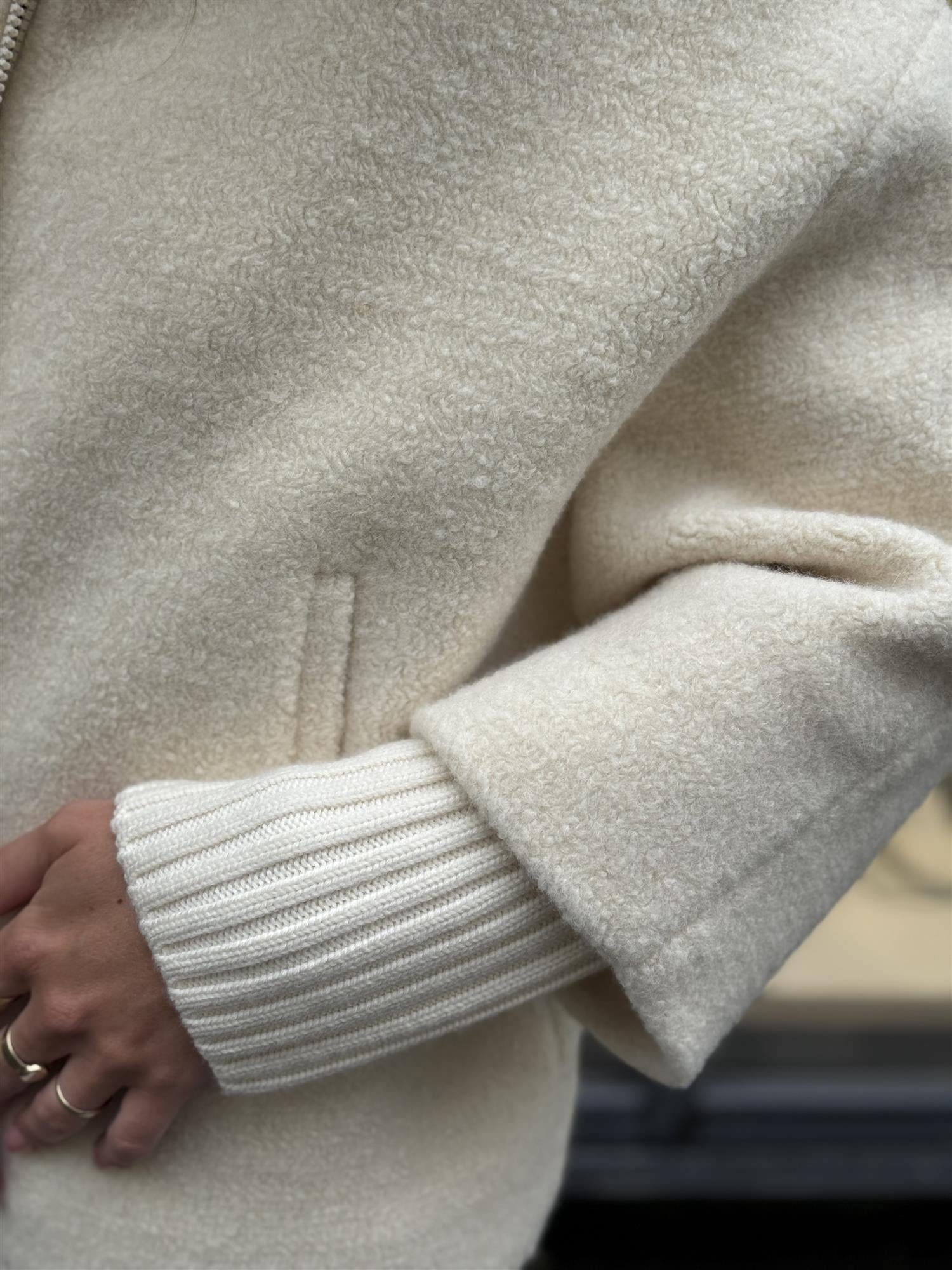 Short oversized white wool coat with knitted details
